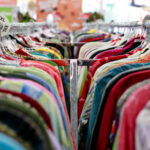 An image looking down a rack of clothing at a thrift store.