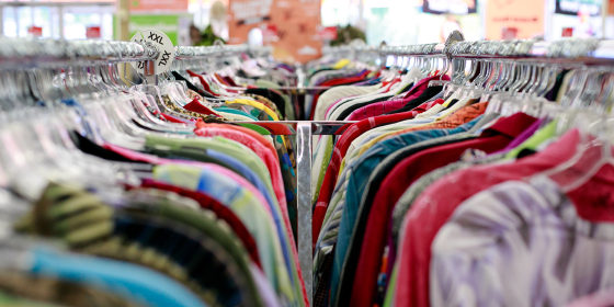 An image looking down a rack of clothing at a thrift store.